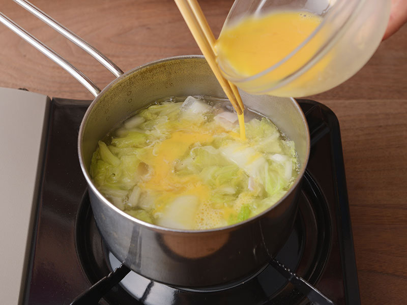 白菜がしんなりとしたら、火を弱めて鶏がらスープの素を加え、塩で味付けします。