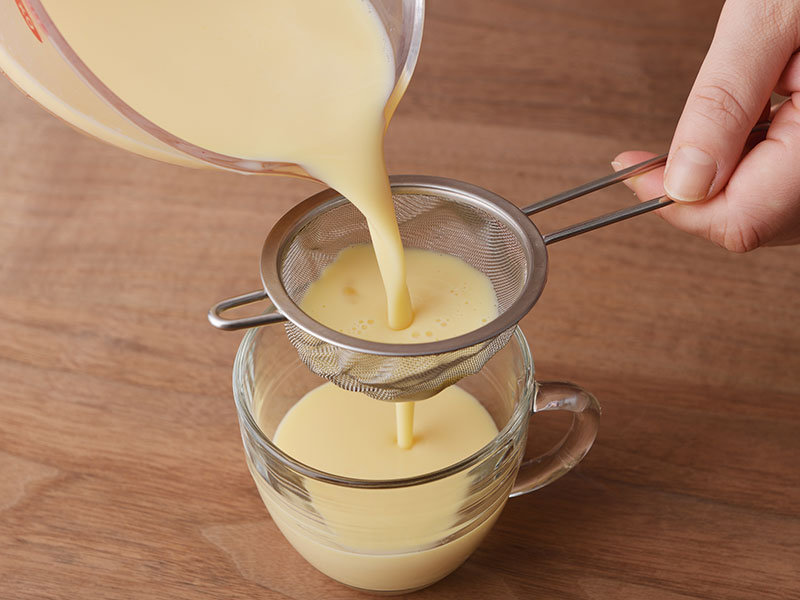 バニラエッセンスを加え、茶こしやざるなどでこしながらマグカップに注ぎます。